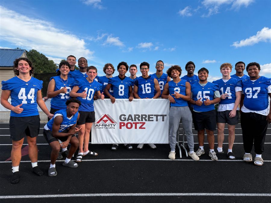 Youth football team holding Garrett Potz sponsor banner